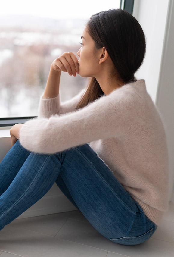 Depressed woman looking at an apartment window