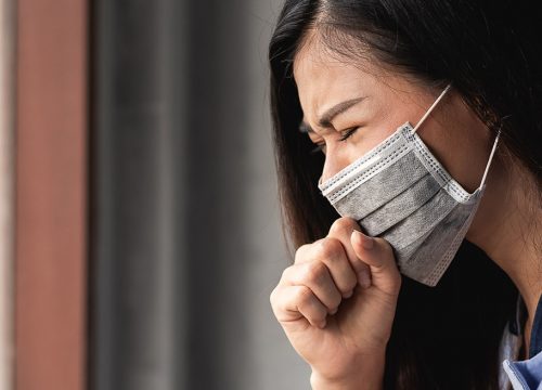 Woman wearing a mask and suffering from post-COVID symptoms