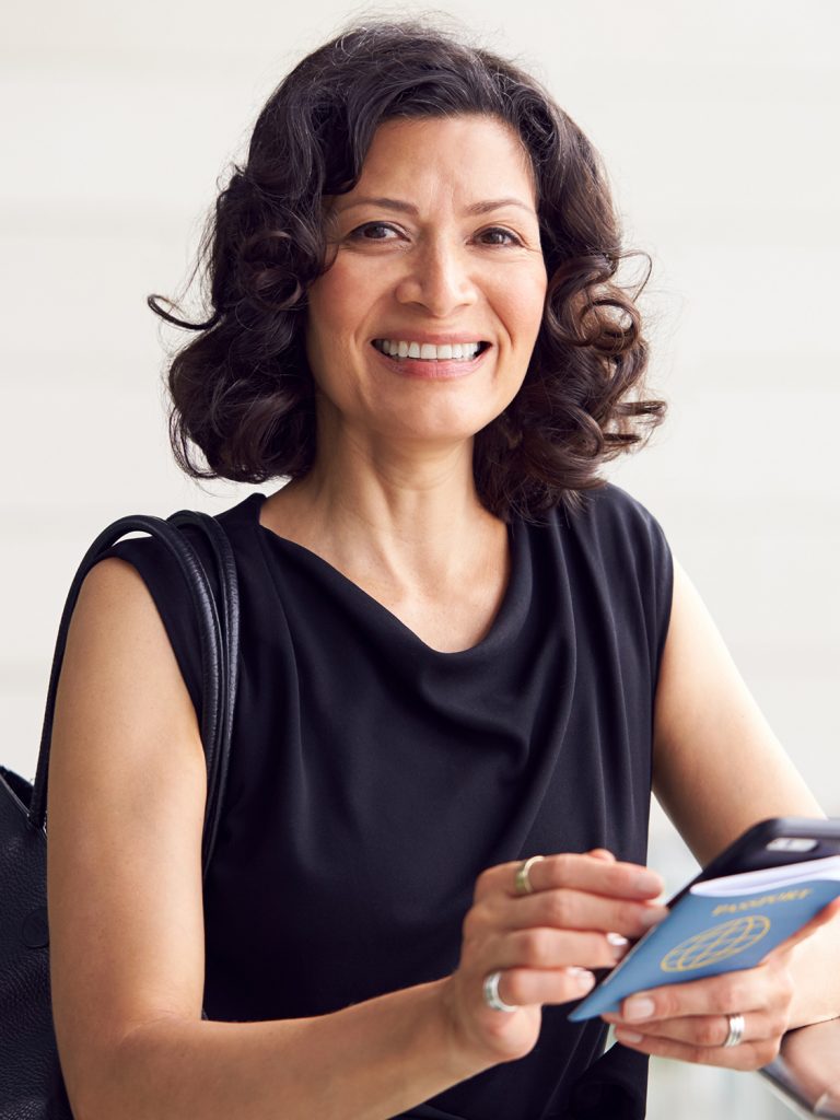 Smiling, middle age woman holding her passport